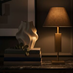 A curated, high-end console table vignette with a sculptural vase, art books, and a brass lamp, representing sophisticated execution.